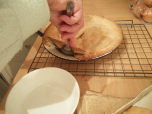 The tart being lifted from the tin