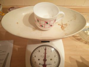 The sugar in the cup on the scales