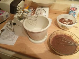 The electric mixer empty and the food mix in the bowl next to it