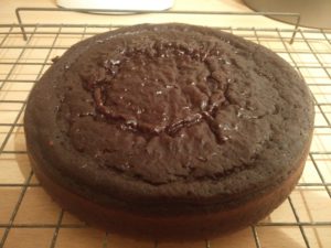 One cake half sitting on the cooling rack