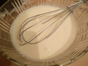 Using a whisk to stir the sugar and whipping cream