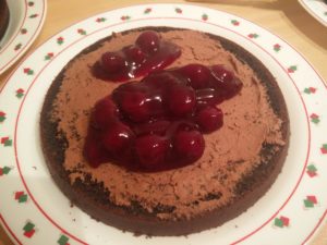 The base layer of the cake with cherries added