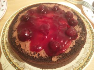 Cherries have been added to the second cake layer and spread over it