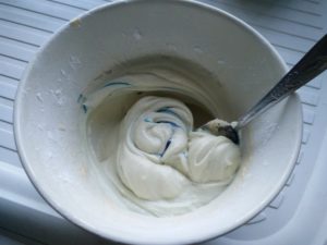 The icing and food colouring being mixed together