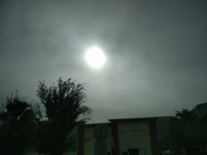 The sun appearing through some clouds