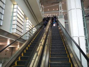 Two escalators going up into the terminal building from the train station