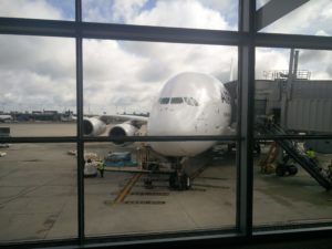 An Airbus A380 docked at a gate, with the wheels on the stop markings
